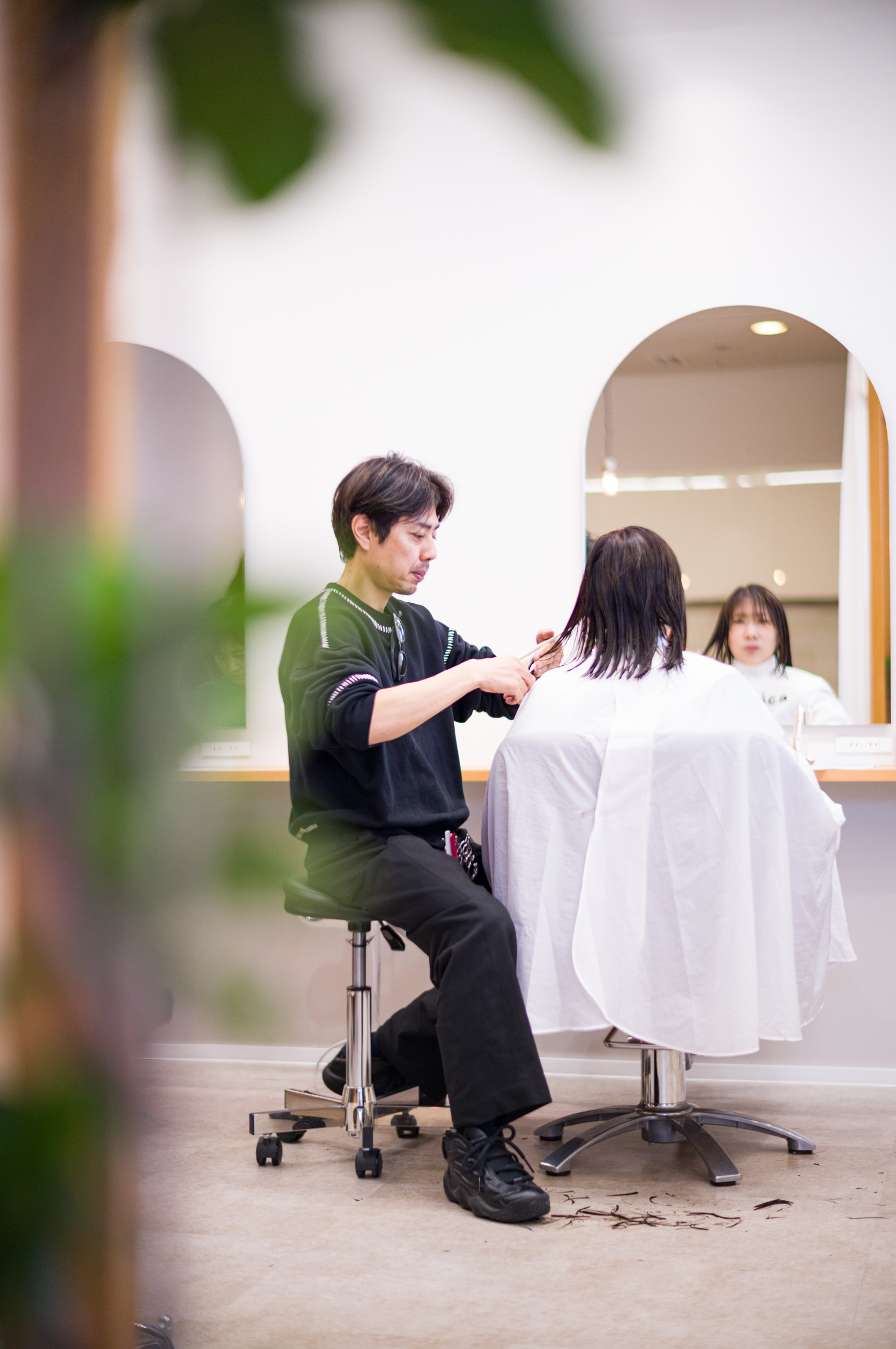 美容室で技術を教わりながら施術している様子