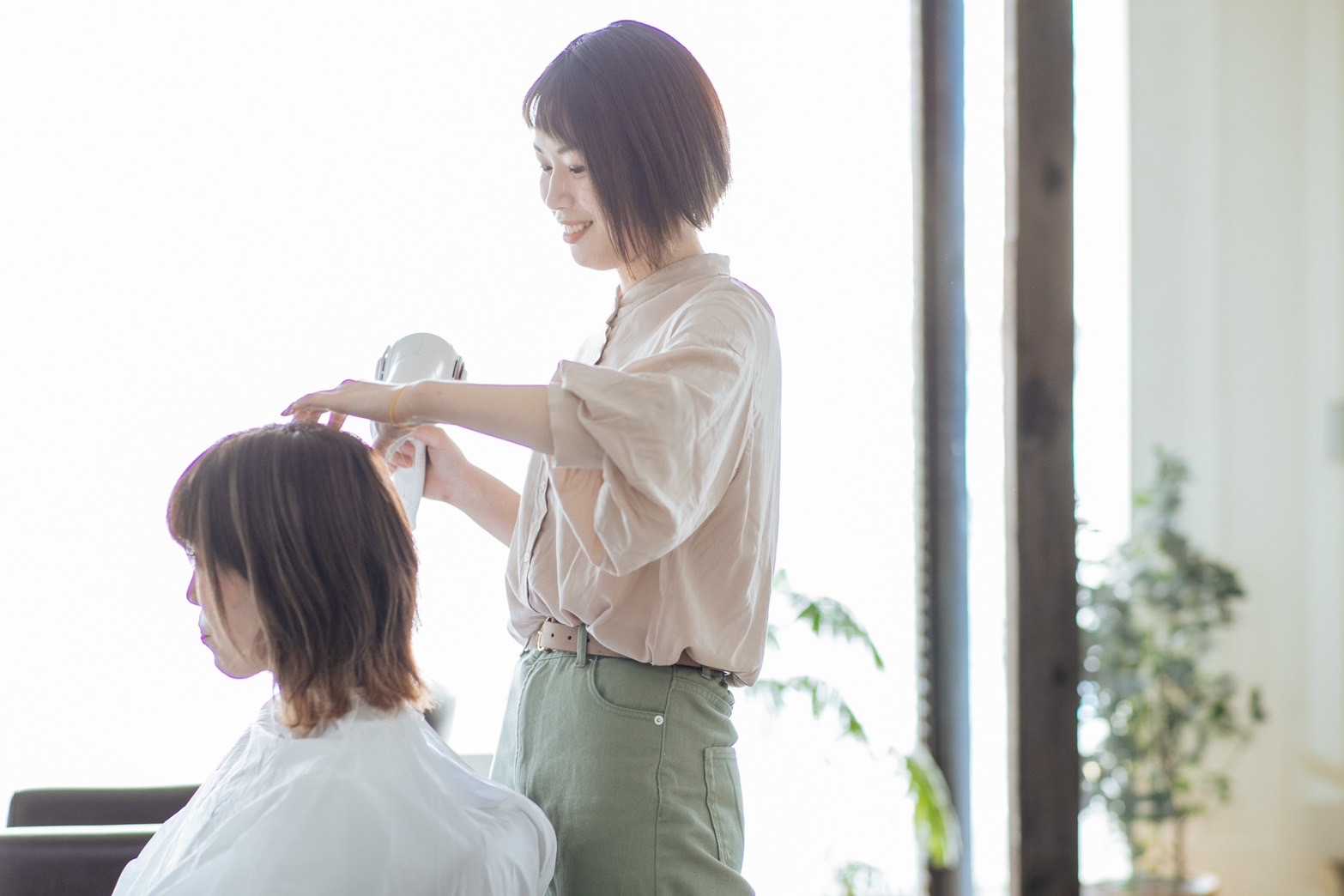 明るい美容室でスタッフが施術している様子